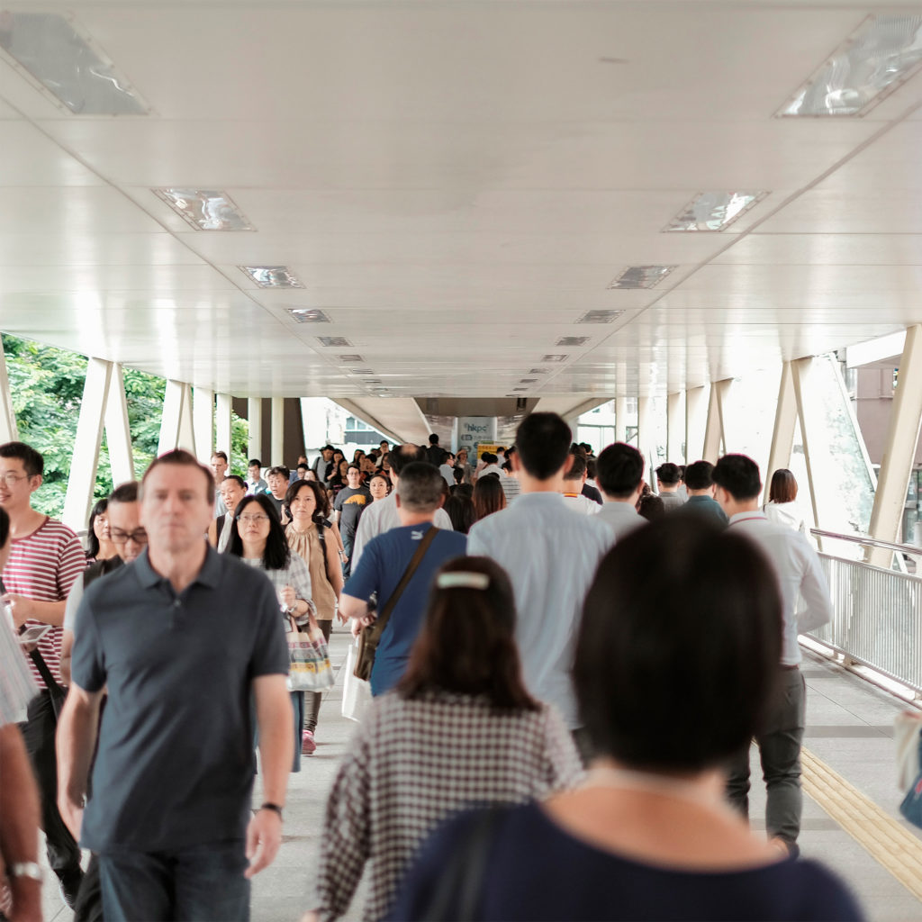 A crowd of people walking down the hallway.